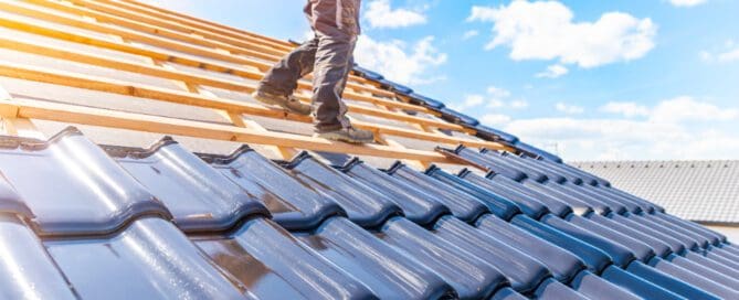 Roofer walking on a roof that has been half finished