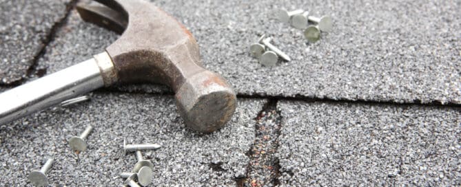 Hammer and nails on roof, roof repair concept.