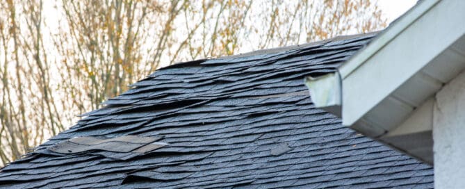 Old roof shingle on the roof of house needs replacing.