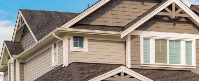 Brown house with brown roof and blue sky background.