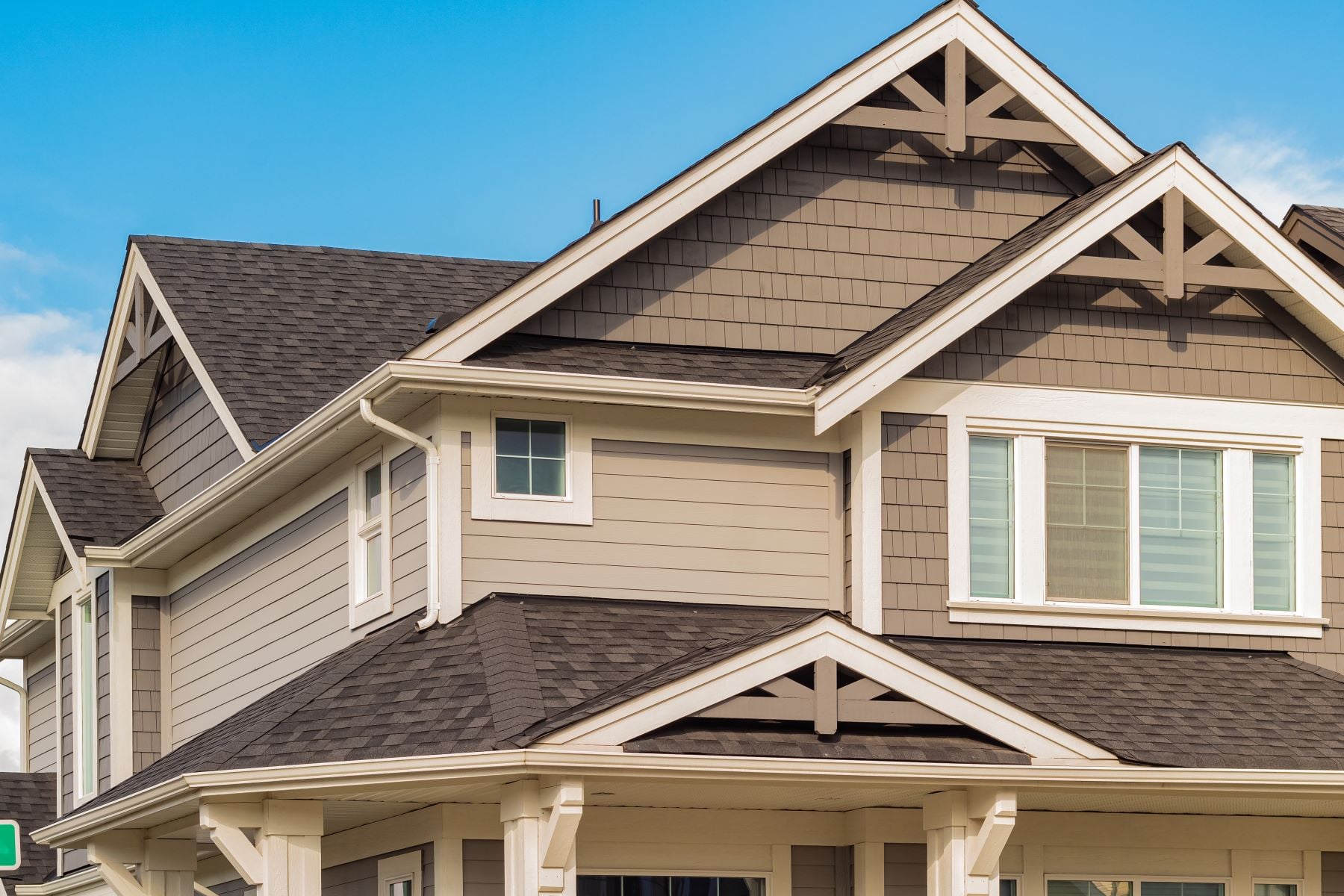 Brown house with brown roof and blue sky background.