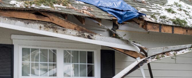 Damaged roof with snow and plastic
