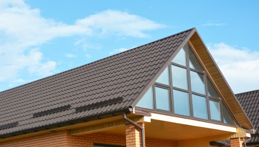Side view of brown shingle roof in house with windows