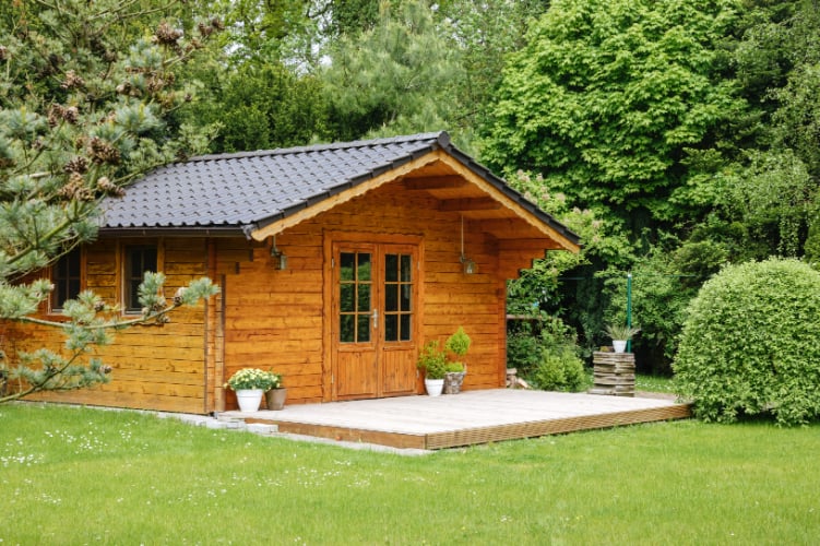 Small shed made of wood in yard.