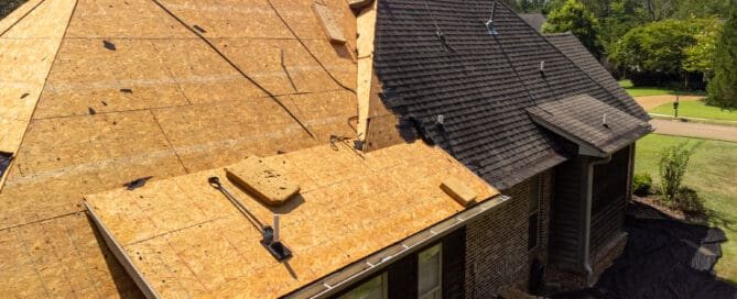 A roof partially covered with wooden boards, showcasing the construction process with tools and roofing materials.
