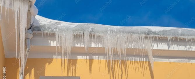 Ice on roof of yellow house.