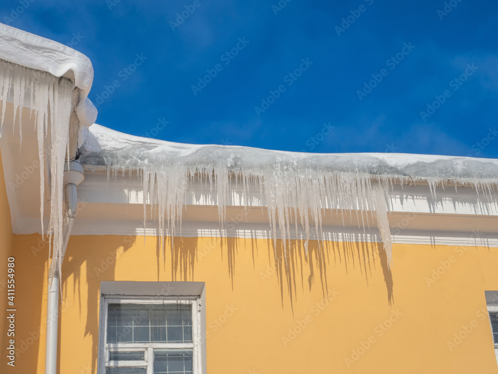 Ice on roof of yellow house.