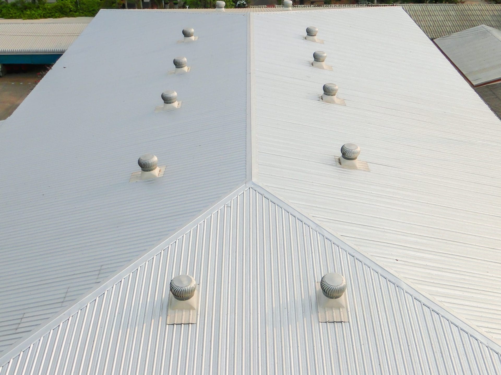 Metal sheet roofing on commercial construction with blue sky.