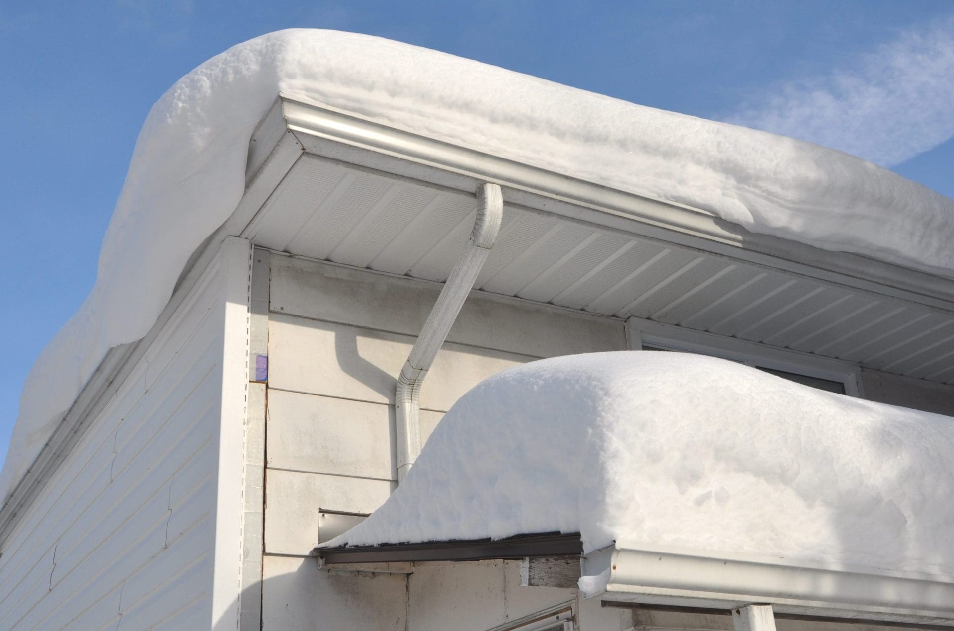 Thick snow on roof of house.
