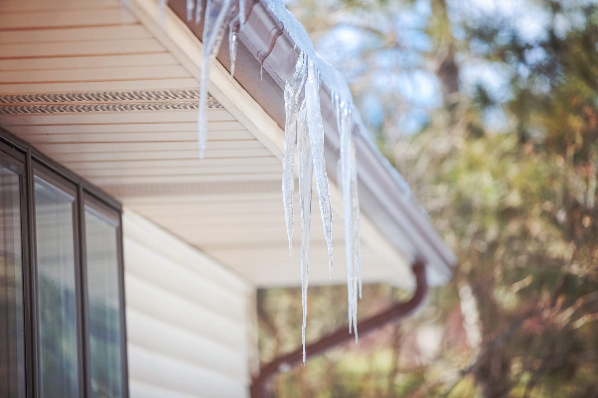 Ice dam in gutter and ice frozen on roof in winter.