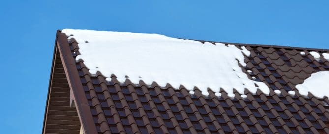 Closeup of house roof top covered with snow in cold winter.