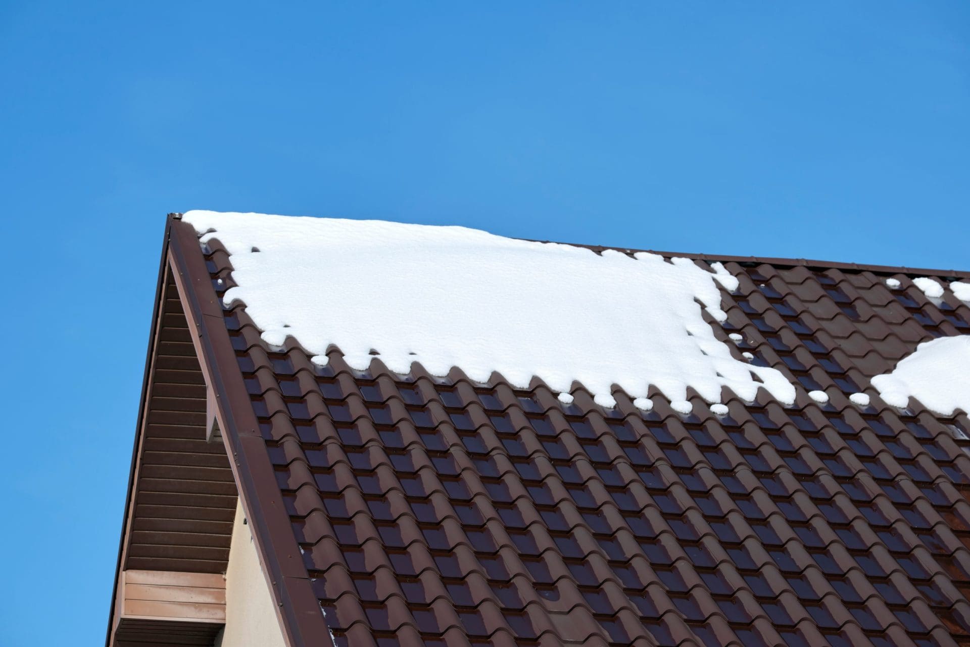 Closeup of house roof top covered with snow in cold winter.