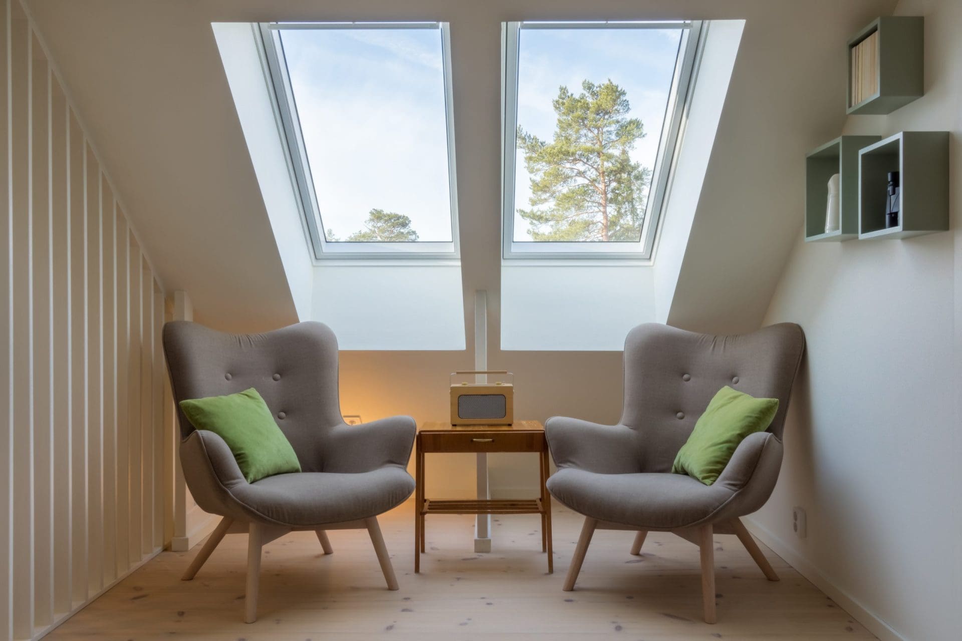 A cozy seating area with two armchairs under large skylight windows, letting in natural light and offering a view of the trees outside.