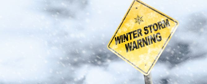 Winter storm season with snowflake symbol sign against a snowy background and copy space.