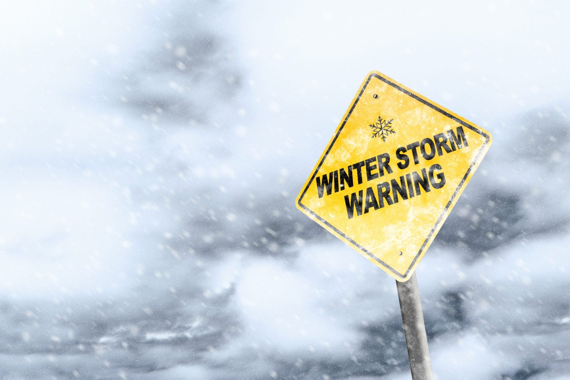 Winter storm season with snowflake symbol sign against a snowy background and copy space.