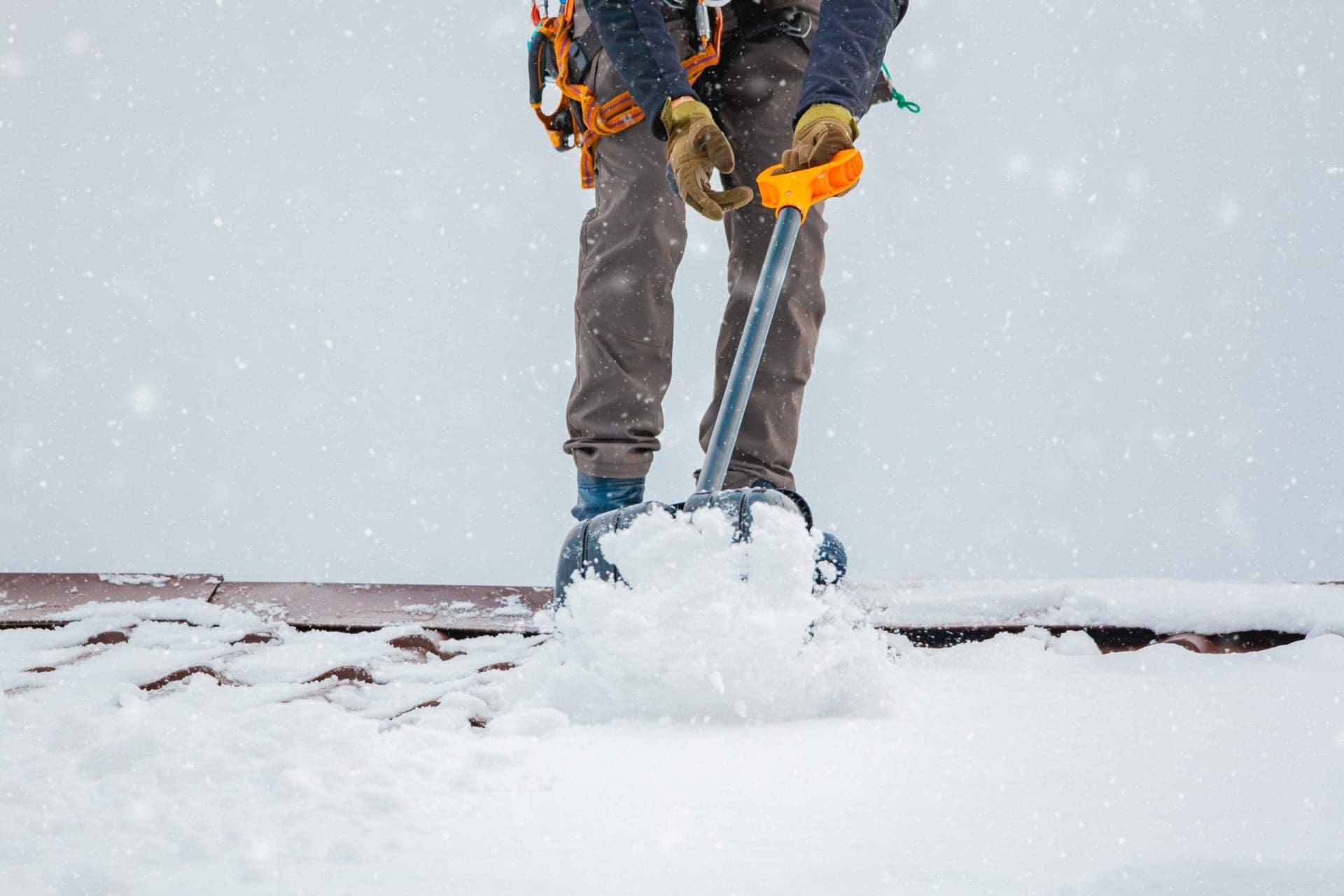 Person with shovel, removing snow from roof.