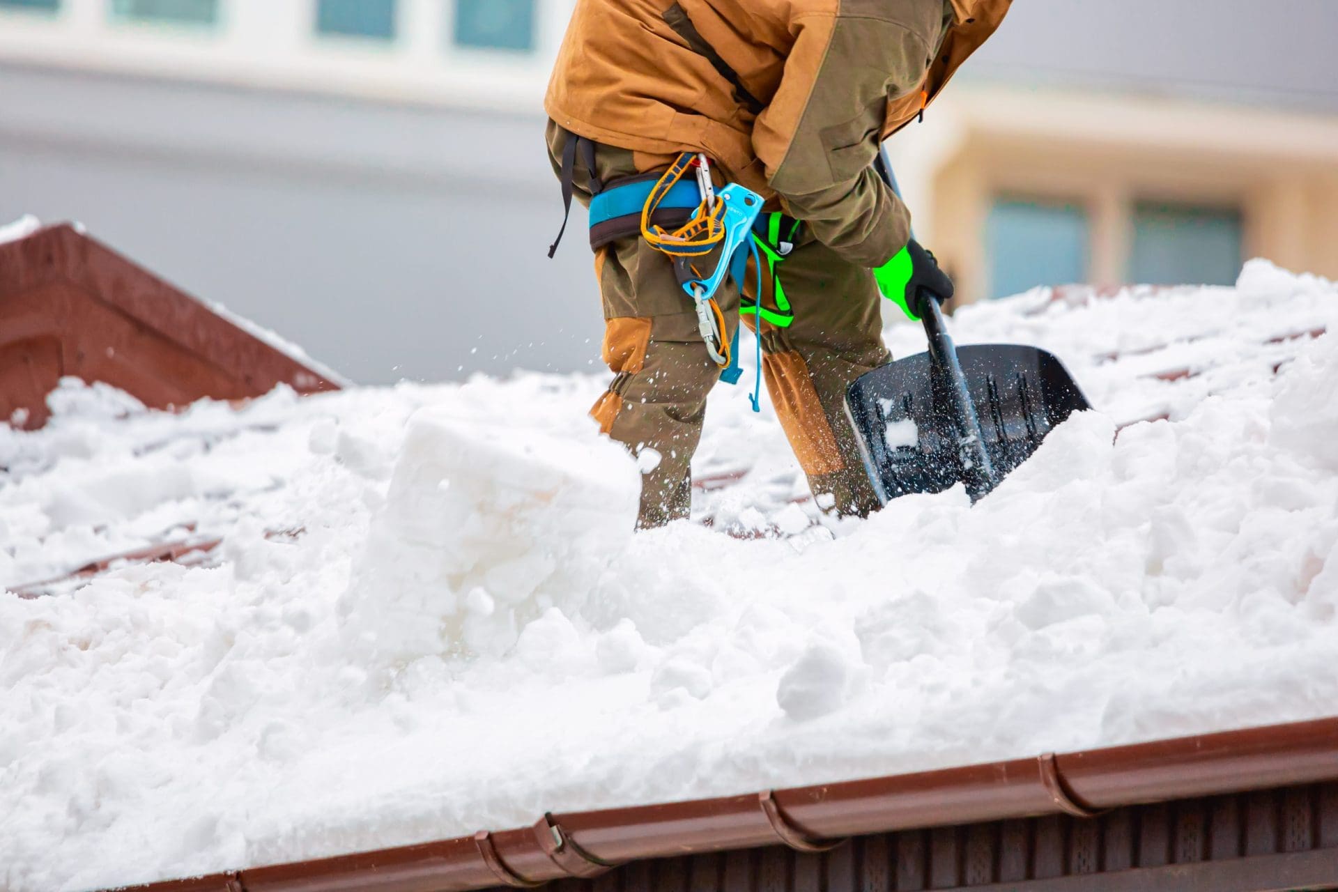 Person shoveling snow from roof.