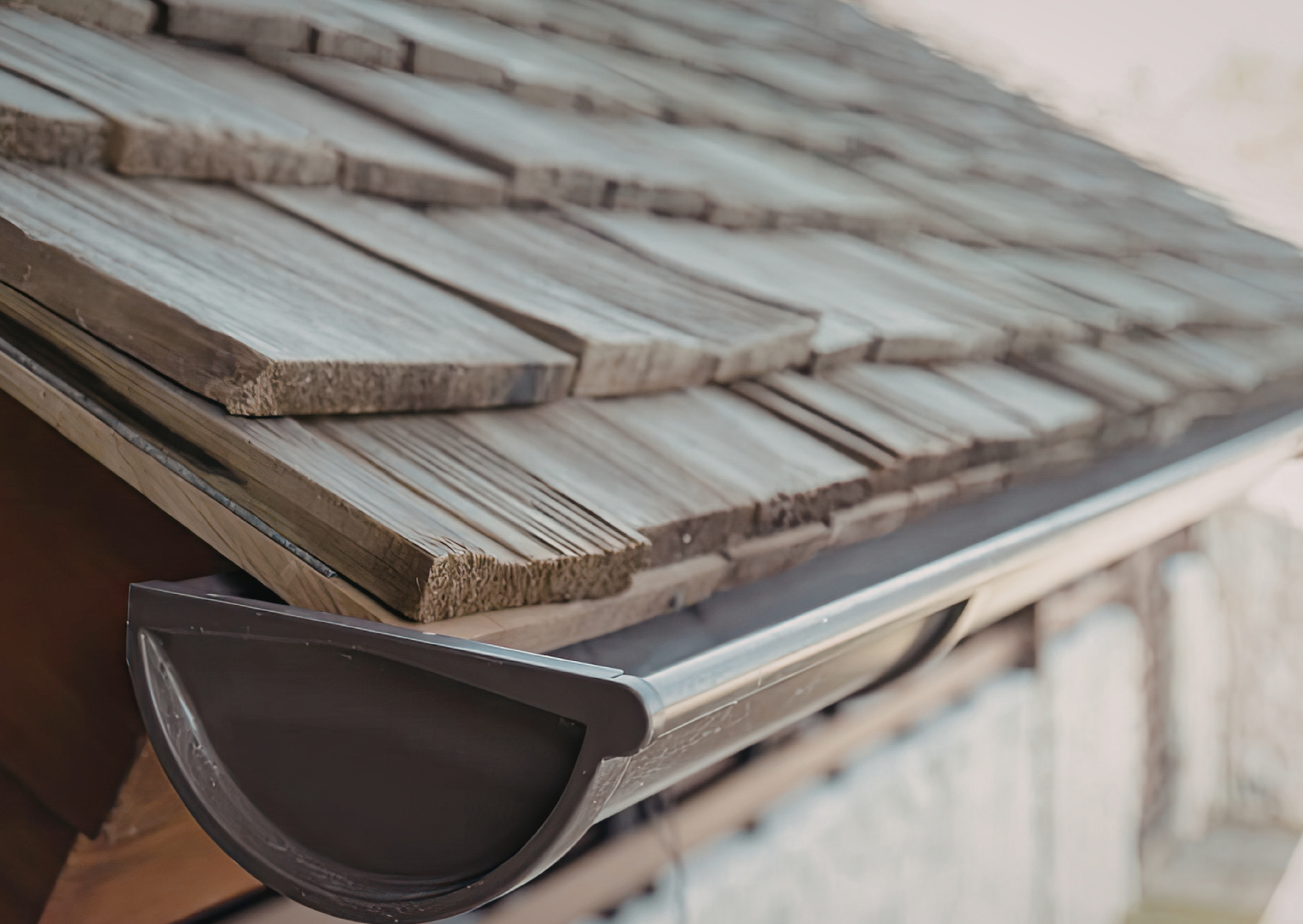 Close-up of water spilling over a roof gutter during rain.