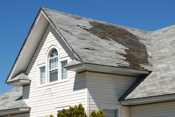 House exterior with clear damage to the roof.